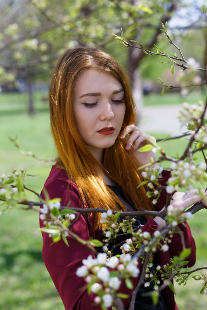 红头发的苗条女孩在公园的树林中图片下载
