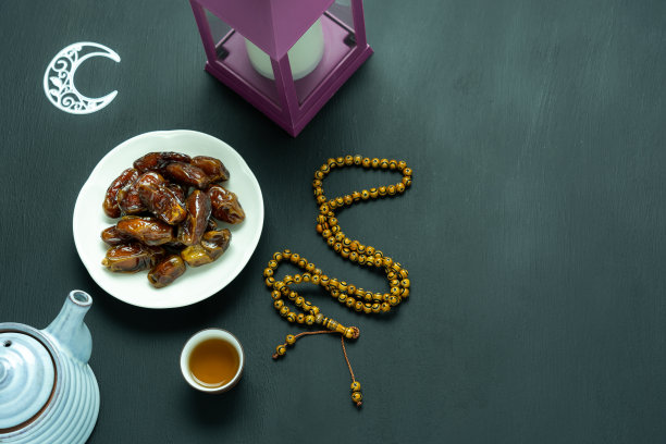 桌子顶视图航空图像装饰斋月Kareem节日背景。平铺枣，念珠，点灯，一杯茶。现代乡村黑色木桌上的必备物品。本空间图片下载