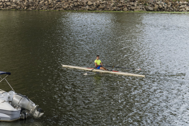 一个阳光明媚的日子，一个男人在河上皮划艇。图片下载