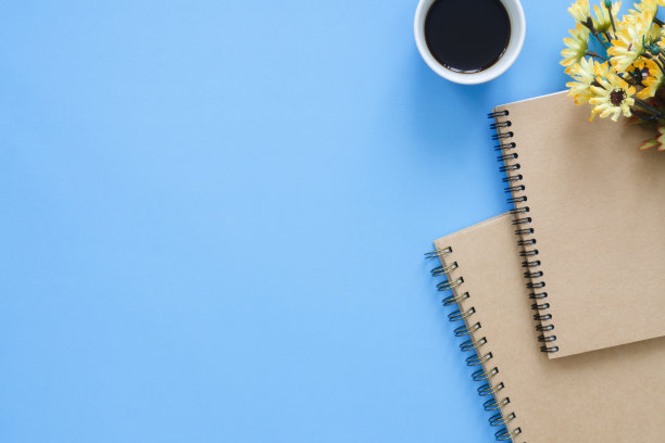 办公室办公桌工作空间-平铺顶视图模型照片的工作空间与杯咖啡，笔记本和装饰在蓝色柔和的背景。粉蓝色复制空间办公桌的概念。图片下载