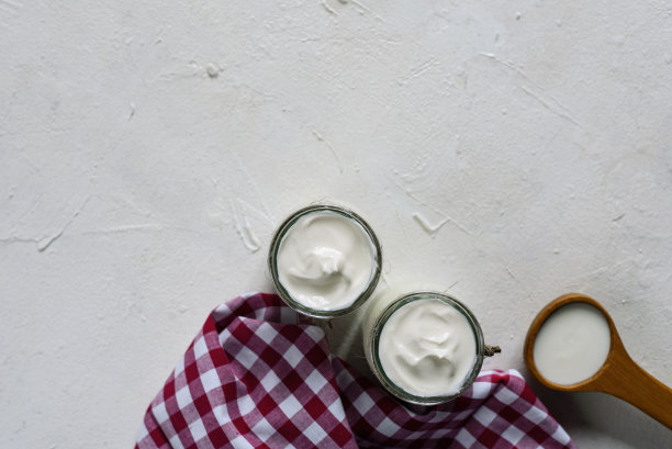 玻璃罐子里的希腊酸奶。白色背景上自制的玻璃瓶希腊酸奶。选择性聚焦，复制空间。图片下载