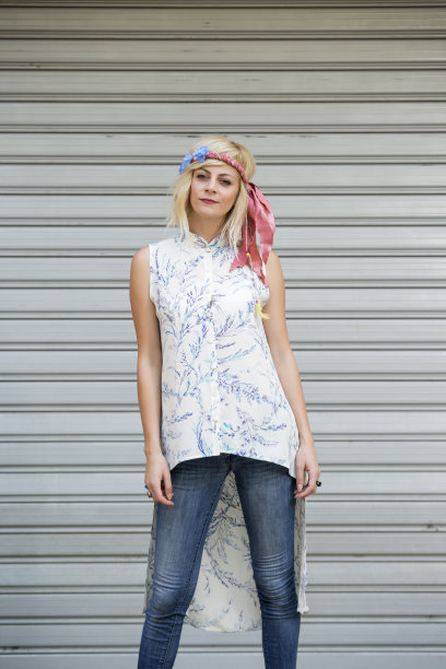 美丽的长金发女孩的肖像，戴着围巾和微笑的裙子像嬉皮在滑动门的背景图片下载