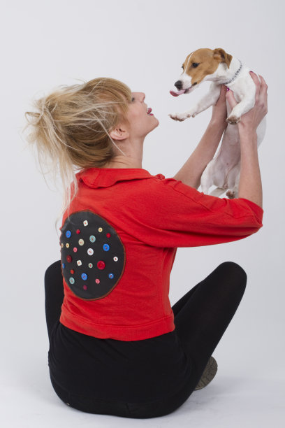 美丽的年轻女子分享爱与她的杰克罗素狗，坐在地板上，而他们正在玩图片下载