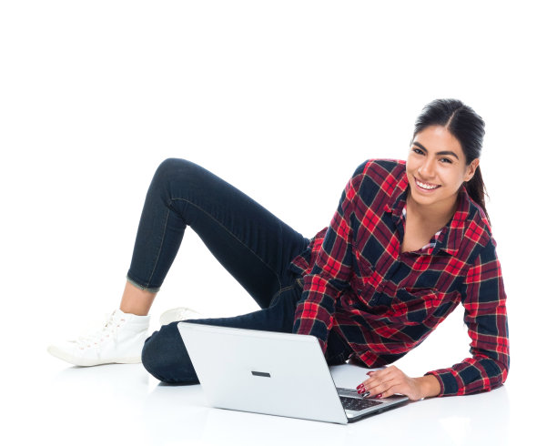 美丽年轻的拉丁美洲女性躺在地板上，用手提电脑图片下载