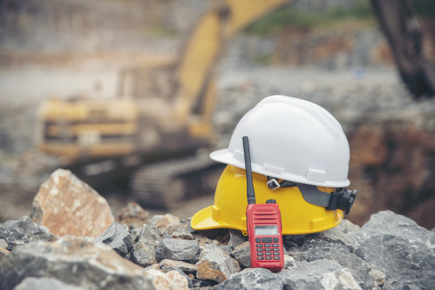 在建筑工地(采石场)放置安全帽(安全帽)及手提收音机。使用移动式起重机进行人身安全保护的设备。安全设备的概念。图片下载