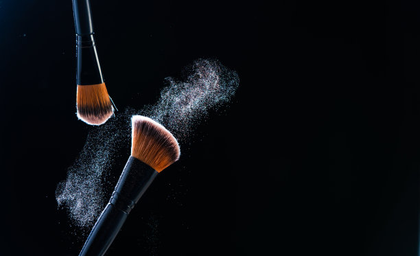 在黑色背景上使用粉末状的化妆刷图片下载
