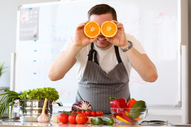 男人拿着切成两半的橙子做眼睛图片下载