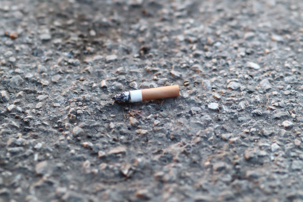 燃烧的烟头，单独，孤立在混凝土上。香烟在人行道上图片下载