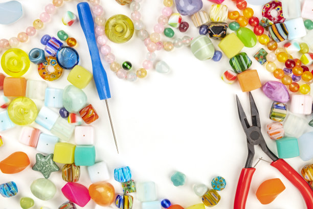 上面的照片，许多不同的珠子与工具制作珠宝，在一个白色的背景与复制空间图片下载