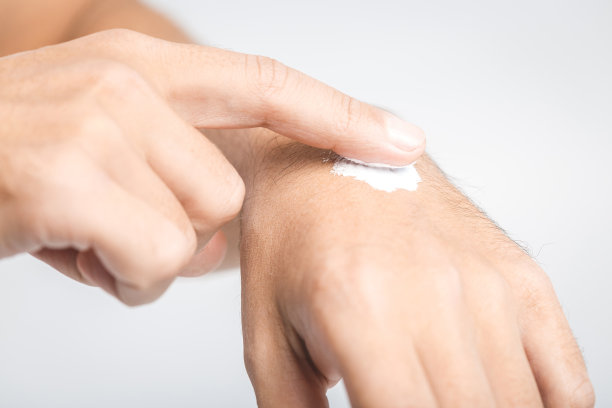 男子在白色背景上涂护手霜，特写图片下载