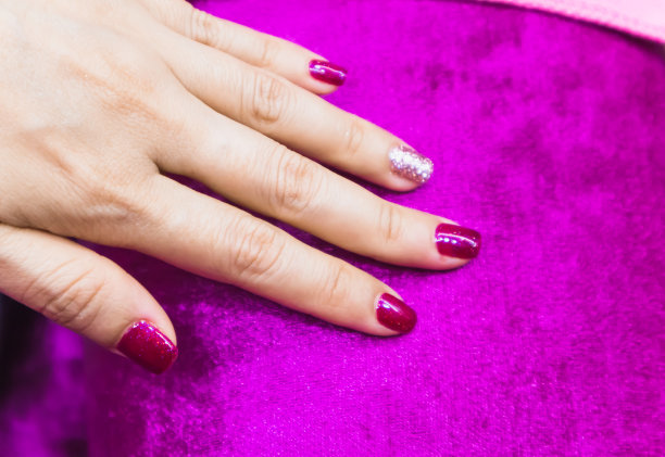 明亮的节日drak粉红色美甲在女性手上图片下载
