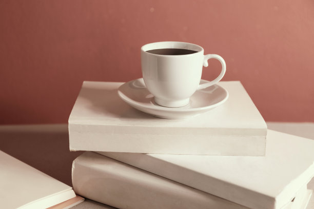 在一堆合上的书上喝杯咖啡图片下载