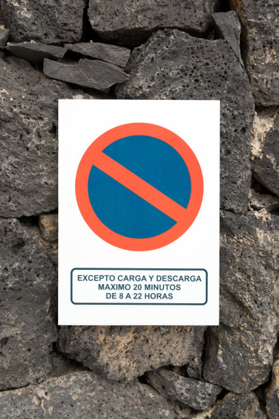 禁止在石头上张贴有西班牙语信息的停车标志图片下载