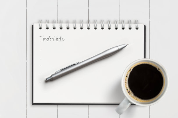用德语写着“待办事项清单”的笔记本，上面是白色的木制背景图片下载