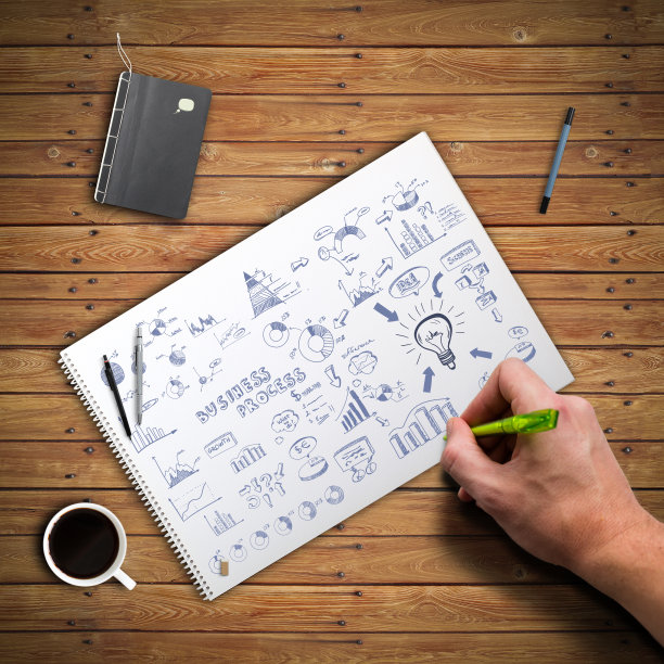 Hand正在一个木制的记事本上画一个复杂的商业策略图片下载