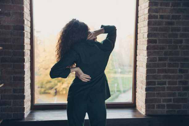 背面，背面，背面，视图，照片，疲惫，衣领，站立，风格有症状，背部，颈部，做按摩，完成任务，身体护理，时尚，漂亮的夹克，裤子，波浪卷曲的发型，工业图片下载