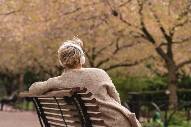 女人在公园里放松和听音乐图片下载