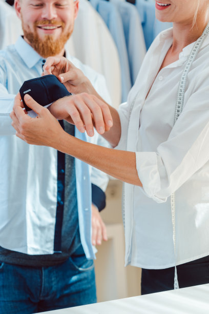 一名男子在裁缝工作室试穿一件定制衬衫图片下载