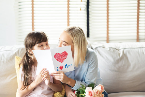 女儿用玫瑰和明信片问候妈妈。图片下载