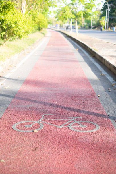 红色自行车道沥青纹理与阳光在早上的背景图片下载