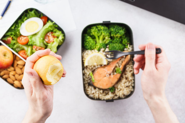 一名男子在工作桌上用外卖午餐盒吃午餐。图片下载