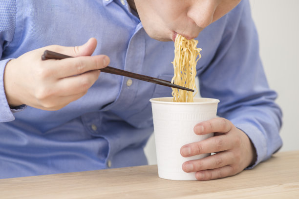 一个人在吃一杯方便面。素材图片