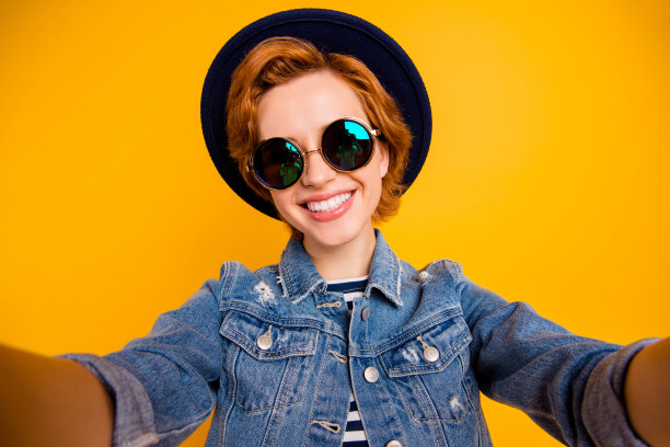 特写照片有趣的funky狐狸她她的夫人做自拍说话告诉skype的朋友戴眼镜复古帽休闲条纹t恤夹克牛仔裤牛仔孤立的黄色明亮的背景图片下载
