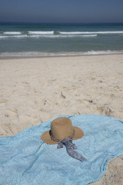 沙滩上的帽子和画布，背景是大海图片下载