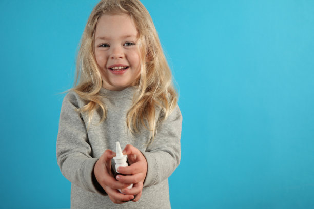 喷雾鼻子在小可爱的女孩手中。治疗鼻炎，过敏，感冒和流感图片下载