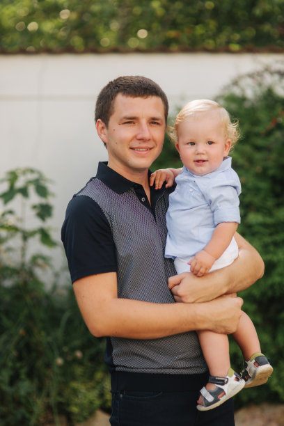 父亲与太阳。小男孩和爸爸在一起。爸爸把儿子抱在怀里图片下载