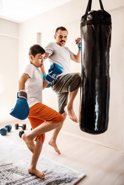 小男孩拳击手与教练练习拳-综合格斗练习图片下载