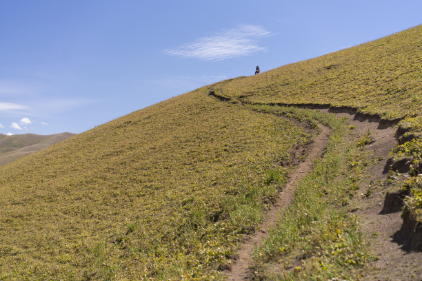 马背上骑马的人在山顶附近的高山，吉尔吉斯斯坦图片下载