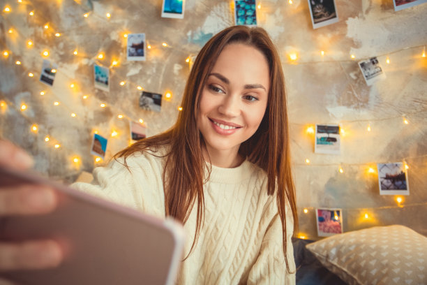 年轻女子周末在家装饰卧室自拍照片图片下载