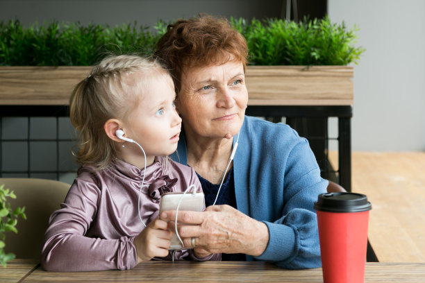 祖母退休了，孙女在玩电话。图片下载