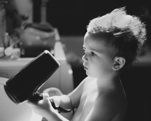 卷毛小孩在用吹风机图片下载