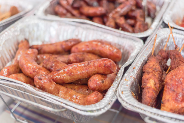 在市场摊位的铝箔盒上的亚洲香肠图片下载
