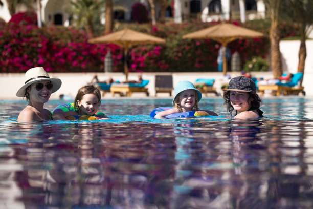 朋友们和孩子们在游泳池里游泳。图片下载