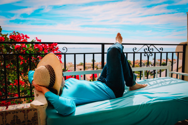 年轻女子在风景优美的阳台露台上放松图片下载