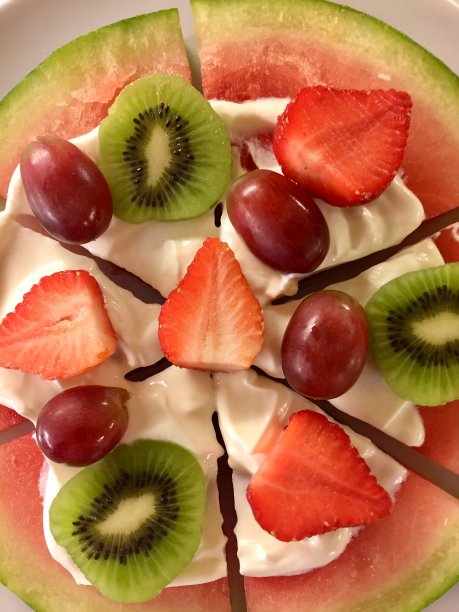 由西瓜片、奶油希腊酸奶、草莓、猕猴桃和红葡萄制成的健康披萨甜点，水果披萨图片布丁图片下载