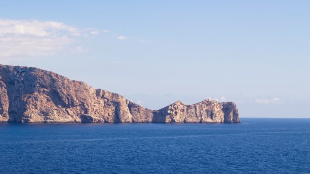 一座孤立的灯塔，紧靠悬崖，被地中海包围。孤独的概念形象。图片下载