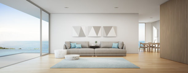 海景餐厅和客厅的豪华夏季海滩别墅与游泳池附近的木制露台。度假屋或度假别墅的大灰色沙发。图片下载