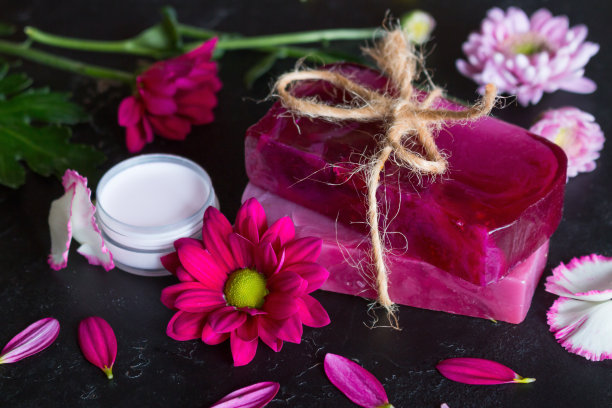 肥皂和奶油手工花在一个黑色的背景特写图片下载