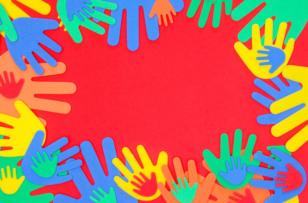 泡沫剪出红色、橙色、黄色和绿色的奇特手形，在朴素的背景上图片下载