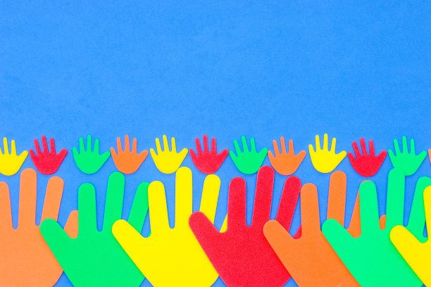 泡沫剪出红色、橙色、黄色和绿色的奇特手形，在朴素的背景上图片下载