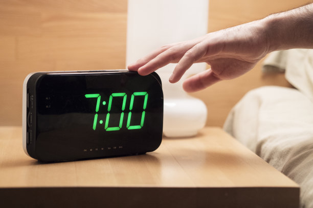 早上7点，一名男子试图关掉数字闹钟。图片下载