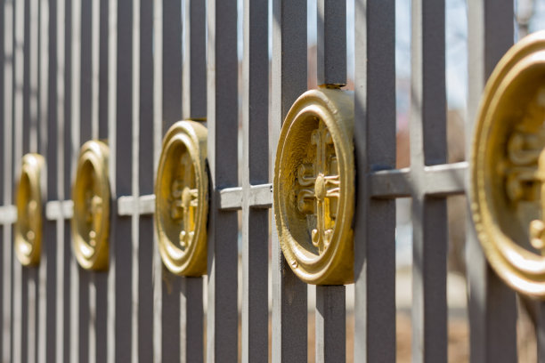 巨大的铁栅栏带有装饰元素，栅栏围绕着庙宇图片下载