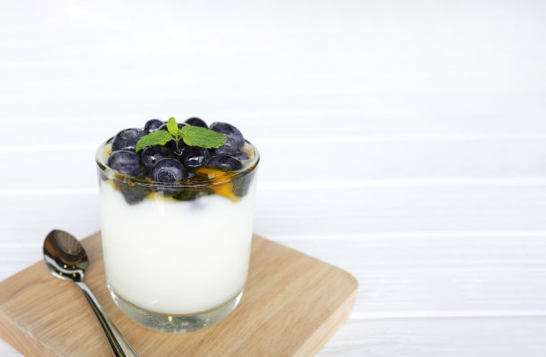 酸奶蓝莓果实洒蜂蜜为健康和白木背景。图片下载
