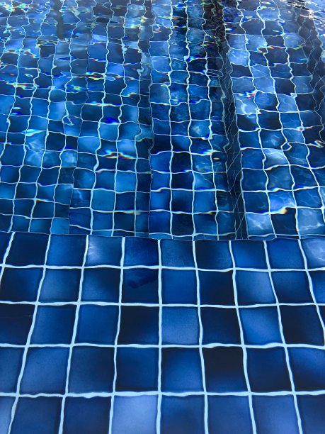 游泳池台阶和墙壁的边缘图像与方形绿松石和蓝色马赛克瓷砖，壁纸背景与水波纹照片，度假/度假无限泳池与涟漪的水从游泳者游泳图片下载