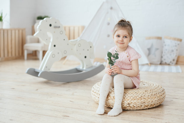 女孩与植物。婴儿室内部有摇马和帐篷小屋。蜡笔的颜色。母亲节图片下载