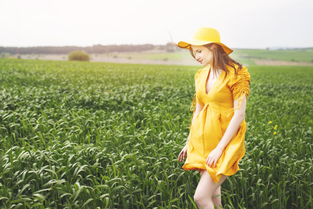 美丽的女孩穿着黄色的裙子在花丛中图片下载